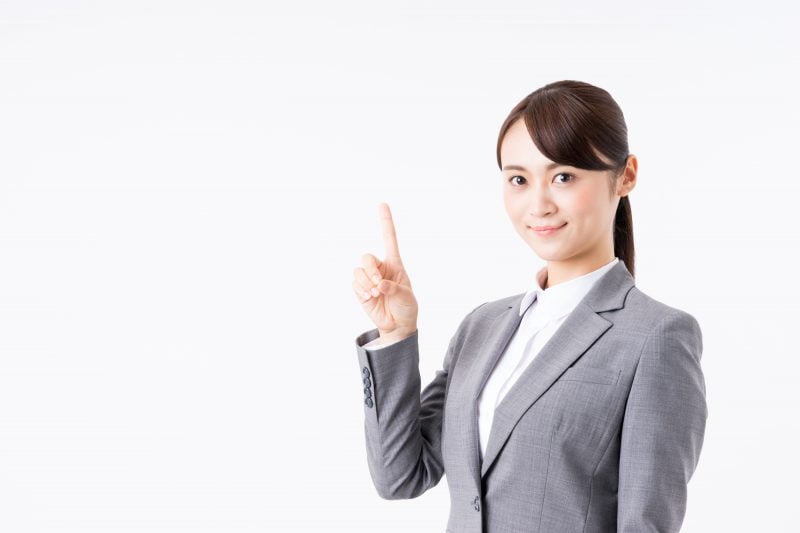 キャッシング-指を立てるスーツ姿の女性
